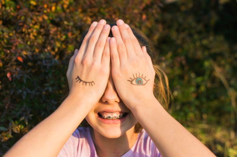 smiling girl covering eyes